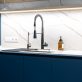 Modern kitchen with matte black faucet and stainless steel sink. Clean marble aesthetic and thoughtful lighting enhance the sleek, functional interior.